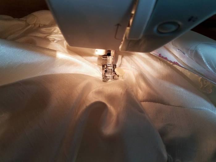 stitching down the pleats around the bustle button