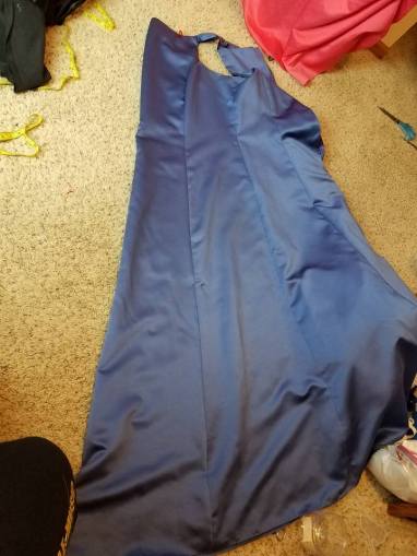 folding the blue dress before slitting up the center front